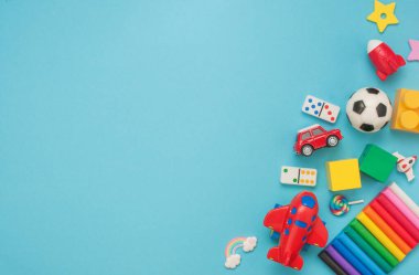 Ahşap ve plastik çocuk oyuncakları çerçevesi mavi arka planda ve boş bir sayfa metin için. Üst manzara, düz uzanma.