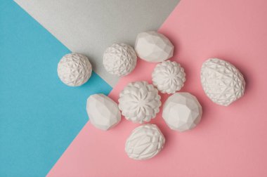 Renk blokları üzerinde geometrik desenli beyaz Paskalya yumurtaları gümüş, mavi ve pembe arka plan ve metin için boş alan. Üst manzara, düz uzanma.