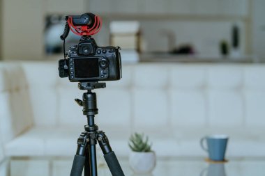 Tripodun üzerinde mikrofon olan kamera oturma odasındaki video kaydı için hazır..
