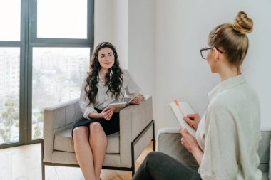 Genç bayan koç ya da antrenör stajyeriyle içeride görüşüyor. Seçici odak.