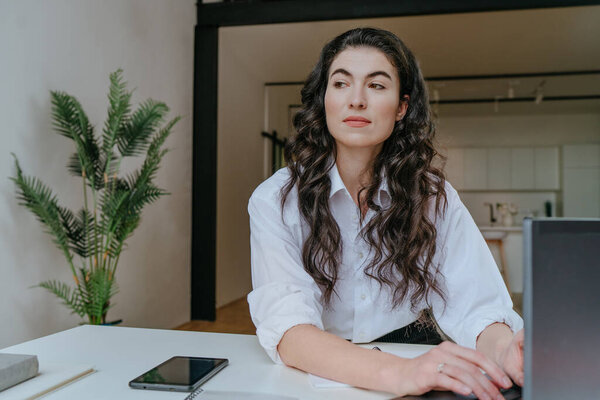 Portrait of beautiful young woman working home using laptop. Selective focus.