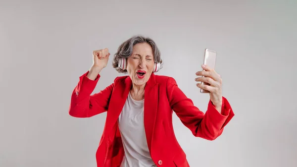 Felice donna anziana ascoltando musica al telefono — Foto Stock