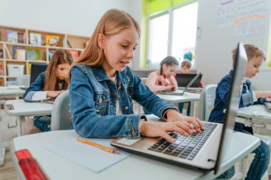 Elementary school students learning in the classroom using laptop