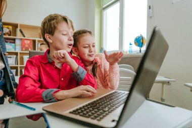 Elementary school students learning in the classroom using laptop