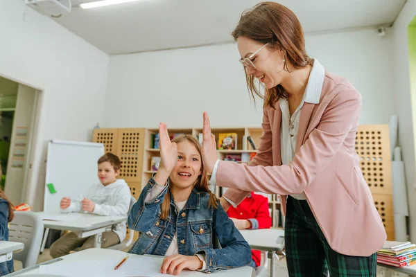 Žena učitel pomáhá školačka ukazuje na něco na svém notebooku — Stock fotografie