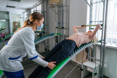 Özel rehabilitasyon cihazı üzerinde çalışan kadın bir doktor rehabilitasyon uzmanı.