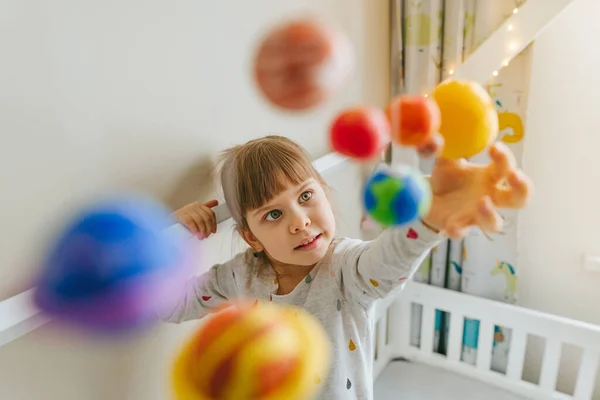 Маленька дівчинка грає з іграшковими планетами, зробленими самим собою з барвистої глини в приміщенні — стокове фото