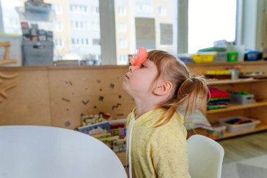 Konuşma terapistinin seansındaki kız. Anaokulunda konuşmanın gelişimi hakkında ders.