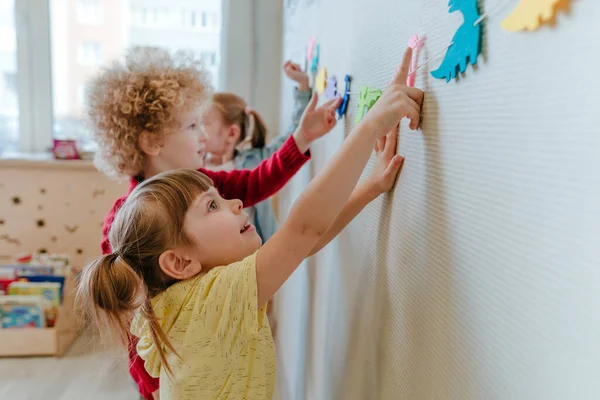 Anaokulunda oynayan anaokulu öğrencilerinin duvarlarında renkli dinozor figürleri var. Seçici odak.