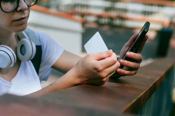 Jeune femme avec casque effectuant le paiement par carte de crédit — Photo