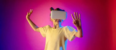 Renkli neon fon üzerine sanal gerçeklik gözlüğü takan sevimli bir kız. Metin için boş alanı olan Panorama arkaplanı.