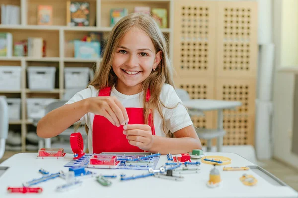 Adolescente chica construyendo mecanismo eléctrico en el aula — Foto de Stock