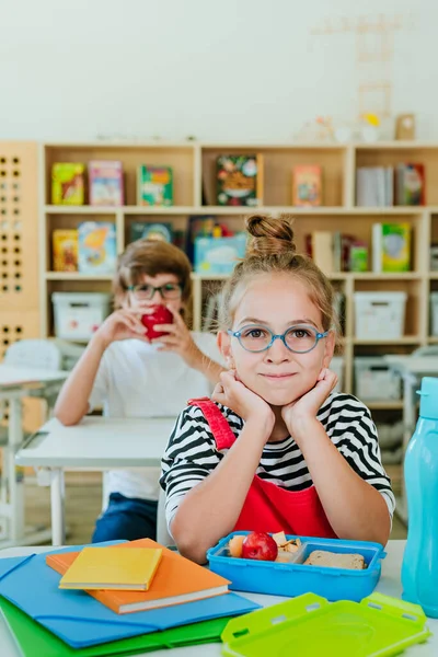 Studenti základních škol jedí z občerstvení ve třídě — Stock fotografie