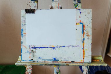 Resim stüdyosunda resim yapmaya hazır bir tuval ve kağıt. Metin için boş boşluk.