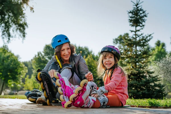 Grandmother and granddaughter are preparing for roller skating