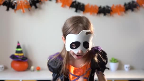Маленькая смешная девочка в костюме ведьмы танцует дома — стоковое видео