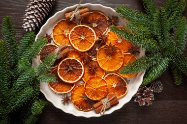 Noel - beyaz tabakta doğal Noel süslemeleri - kurutulmuş portakallar ve tarçın