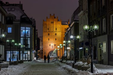 Olsztyn 'deki Yukarı Kapı, aynı zamanda High Gate olarak da bilinir - Olsztyn' deki şehir kapısı, 14. yüzyıldan beri mevcuttur. Kış akşamı.