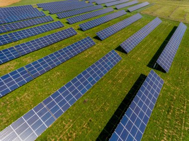 Fotovoltaik çiftlik - güneş ışığından yenilenebilir enerji - yeşil alana kurulmuş fotovoltaik paneller. Orta ölçekli işletmeler için yenilenebilir enerji