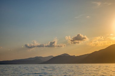 İtalya - Torri del Benaco kasabasında Garda Gölü. Gün batımı, deniz kenarında romantik bir yer, uzakta dağ zirveleri..
