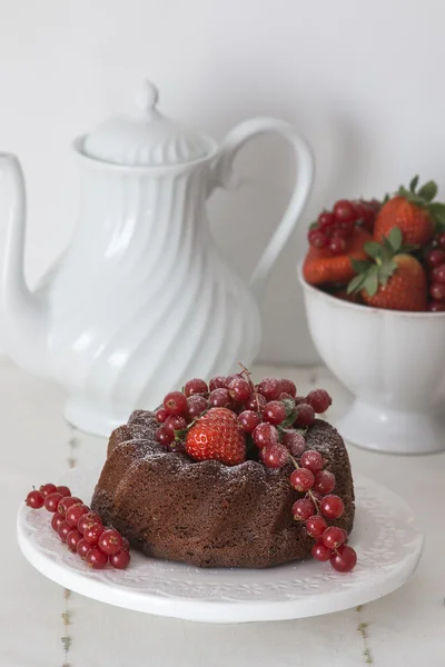 Pastel de chocolate con bayas frescas en una vajilla blanca — Foto de Stock