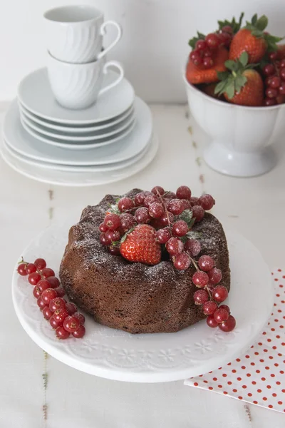 Pastel de chocolate con bayas frescas en una vajilla blanca — Foto de Stock