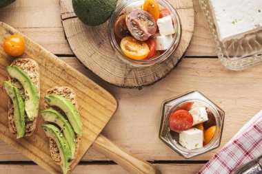 Baharatlar ve üzerine domates salatası ile tost ekmek üzerinde avokado dilimlenmiş 