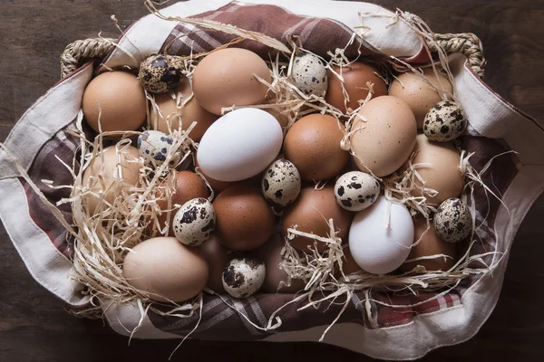 Different kind of raw eggs in a basket