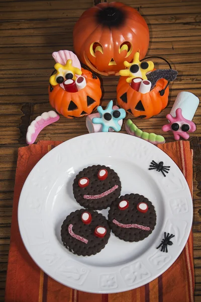 Smiling cookies with candies and pumpkins in Halloween festiviti — Stock Photo, Image