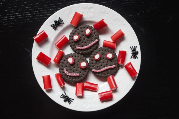 Smiling cookies with candies and spiders in Halloween festivitie — Stock Photo, Image