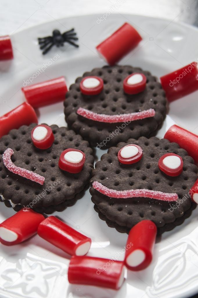 Smiling cookies with candies and spiders in Halloween festivitie