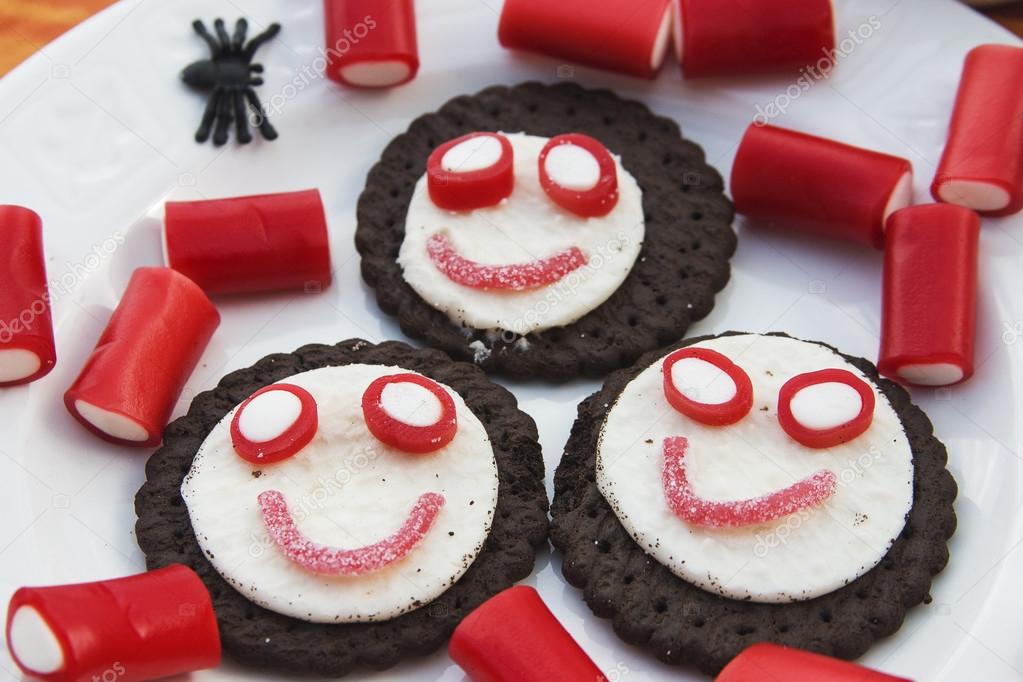 Smiling cookies with candies and spiders in Halloween festivitie