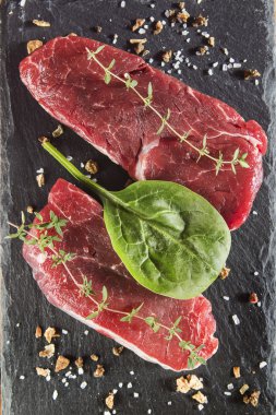 Bir kara tahta üzerinde baharatlar ile çiğ Dana bonfile