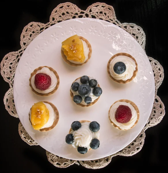 Tartaletas dulces rellenas de crema y, arándanos, frambuesas y —  Fotos de Stock