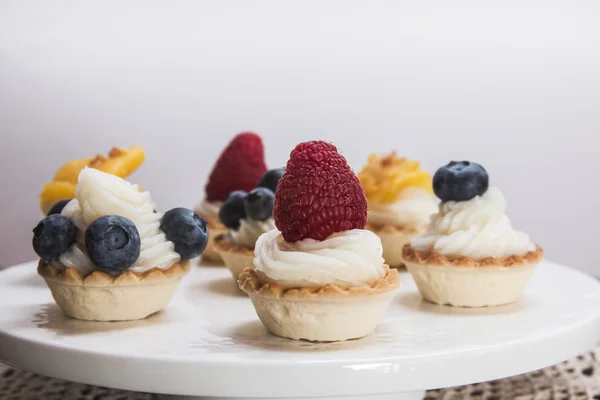 Sweet tartlets filled with cream and , blueberry, raspberry and — Stock Photo, Image