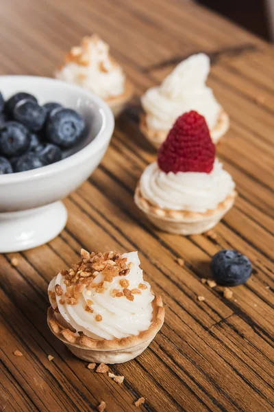 Sweet tartlets filled with cream and , blueberry, raspberry and — Stock Photo, Image