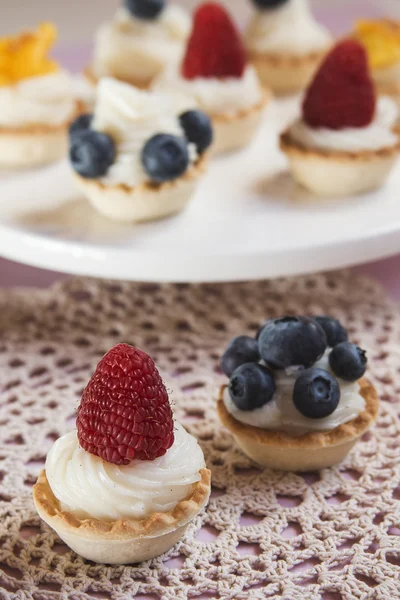 Sweet tartlets filled with cream and blueberry, raspberry and ma — Stock Photo, Image