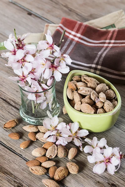 Almonds and flower tree in a wooden background — Stock Photo, Image