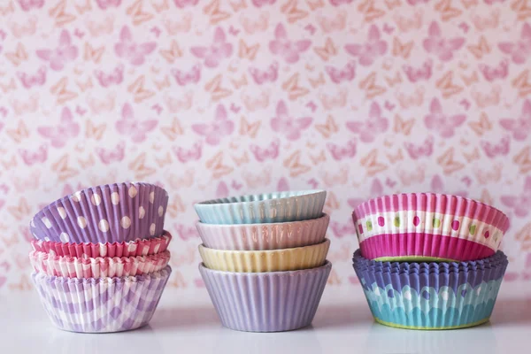 Färgglada cupcake wrappers över en hylla med vintage bakgrund — Stockfoto