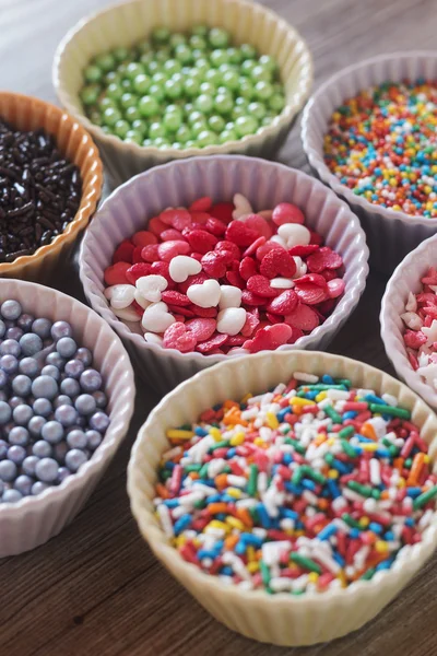 Éclats de cupcake colorés sur une table en bois — Photo