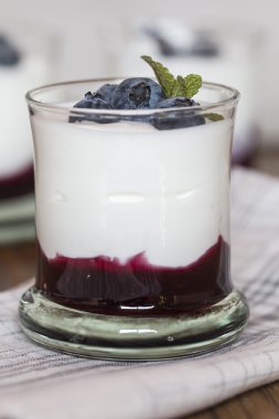 Yoğurtlu taze yaban mersini ve cam kase içinde yaban mersini reçeli