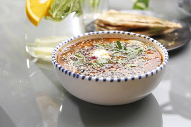 Domatesli mercimek çorbası, ekşi krema ve otlar. Vejetaryen yemekleri, renkli ve iştah açıcı yemekler..