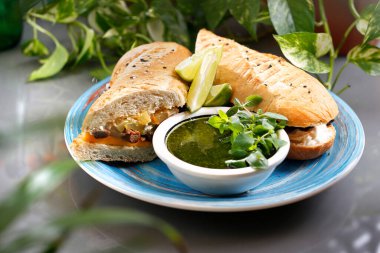 Yeşil pesto soslu sebzeli sandviç ve humus. Sıcak sandviç. Tabakta tabak, yemek fotoğrafçılığı, evlenme teklifi..