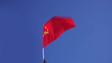 SSCB 'nin kırmızı bayrağı mavi gökyüzüne karşı rüzgarda gelişiyor.