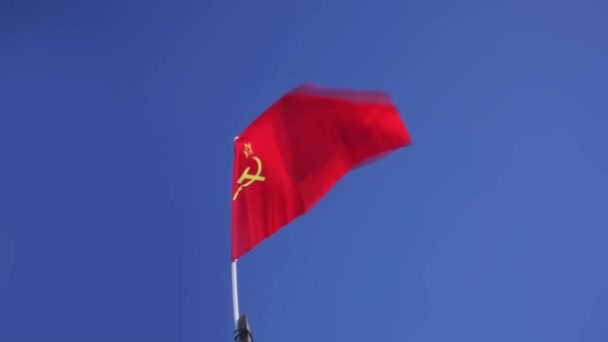 A Szovjetunió vörös zászlaja a szélben a kék ég ellen tör ki. — Stock videók