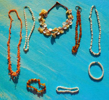 Denizin doğal mücevherleri. Metin için yer aç. Mavi arka planda mercan kehribar inci ve kemik mücevherleri. Üst Manzara. Yüksek kalite fotoğraf