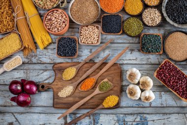 Tahta masada çeşitli organik baklagiller var. Kavanozda ve kaşıkta kurutulmuş bezelye ve bakla konsepti. 