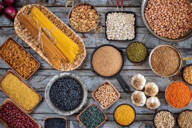 Tahta masada çeşitli organik baklagiller var. Kavanozda ve kaşıkta kurutulmuş bezelye ve bakla konsepti. 