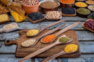 Büyük kuru fasulye çeşitleri. Tahta kaşıklarda kurumuş baklagiller.. 