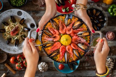 Deniz ürünleri makarnası ve midyeli paella. Spagetti Alle Vongole. Restoranda yemek servisi ve paylaşımı..